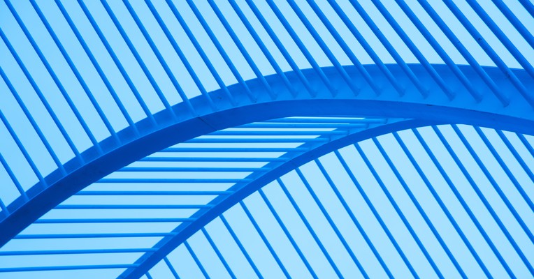 Agentic AI testing: a bold blue arc sweeping across diagonal ribbed panels in an abstract architectural frame