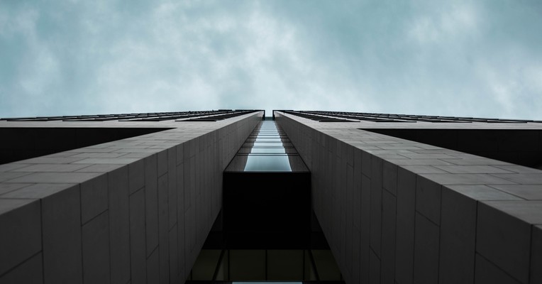 LLM penetration testing: a dark low-angle view up two building faces meeting against a moody grey-blue sky